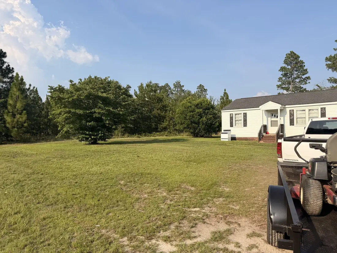 Large mowed yard with lawn equipment on site